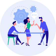 Picture of 3 people at a desk. One is sitting and two are standing and conversing